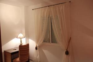 Cette chambre dispose d'une fenêtre avec une lampe et une chaise. dans l'établissement Calle José Payán nº 28, 1º B, à Camas