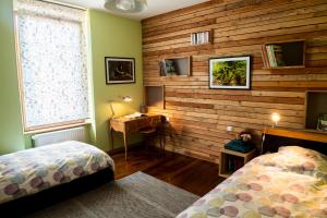 a bedroom with two beds and a desk and a window at L'Enchantraine in Chantraine