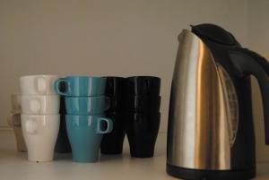 a coffee maker and coffee cups on a counter at Pensión Córdoba in Seville