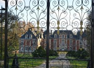 a view of a building through a gate at la picardine in Suzanne