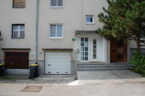 リュブリャナにあるApartments Peter & Free parkingの二戸のガレージドアと木のある家