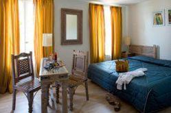 ボーリュー・シュル・ドルドーニュにあるLogis hotel les flots bleusのベッドルーム1室(ベッド1台、テーブル、椅子付)