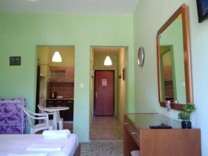 Habitación con cama y cocina con espejo. en Rooms To Let Giannis en Makrýgialos