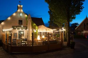 un restaurante con mesas y sillas por la noche en Chalet Zeekraal en Buren