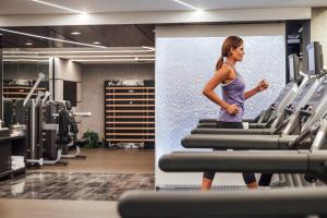 a woman walking on a treadmill in a gym at Sofitel Chicago Magnificent Mile in Chicago