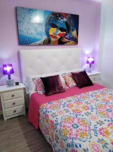 ein Schlafzimmer mit einem Bett und einem Gemälde an der Wand in der Unterkunft Apartamento espectacular in Guardamar del Segura