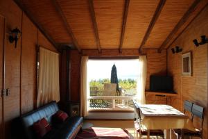 sala de estar con sofá, mesa y ventana en Cabañas Mas Ke Miel en Lago Ranco