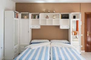 ein Schlafzimmer mit einem Bett sowie weißen Schränken und Regalen in der Unterkunft Urbanizacion La Roca Estudio in Torremolinos