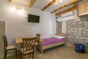 a room with a table and a bed and a table and chairs at Lorena in Trogir