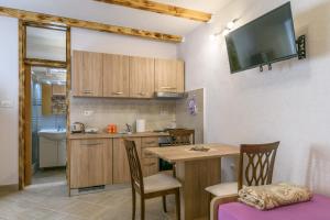een keuken met een tafel en een kleine keuken met een tv bij Lorena in Trogir