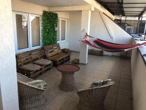 a porch with a hammock in a room with benches at Square Vanilla Apartments in Skopje
