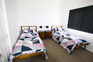 two beds sitting next to each other in a room at Topaz Cottage in Glen Innes