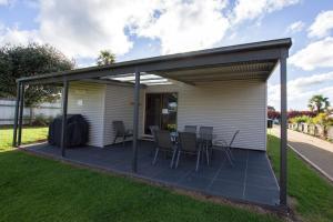 a pavilion with chairs and tables on a lawn at Topaz Cottage in Glen Innes