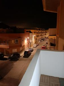 - une vue sur une rue la nuit avec des voitures garées dans l'établissement Apartamento la piedra viva 1 arinaga, à Arinaga