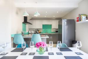 a dining room with a table with wine glasses and pink flowers at James Cook's Retreat in Middlesbrough