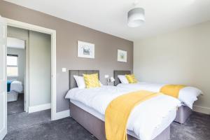 a bedroom with two beds with yellow and white pillows at James Cook's Retreat in Middlesbrough