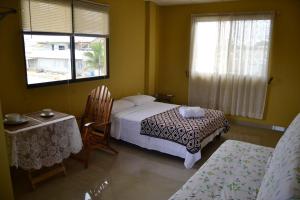 um quarto com uma cama, uma mesa e cadeiras em Suites Sonikikos em Ballenita