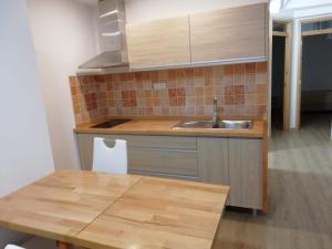 アリナガにあるApartamento la piedra viva 2 arinagaのキッチン(シンク、木製テーブル付)