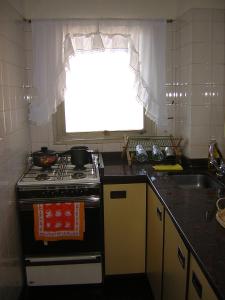 a kitchen with a stove and a sink and a window at Corrientes y Esmeralda in Buenos Aires