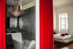a bathroom with a chandelier and a red curtain at Amazing Riverside Balcony 2Br Apartment in Porto