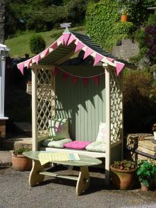 a gazebo with a bench in a yard at Yr Hen Felin - The Old Mill B&B in Morfa Nefyn