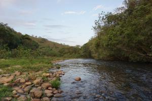 聖羅克迪米納斯的住宿－Pousada Estância Macaúbas -，一条河,河的两边有岩石和树木