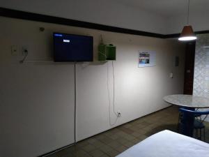 Habitación con TV en la parte superior de una pared en Flat Simples na Praia de Iracema en Fortaleza