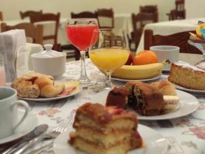 una mesa cubierta con platos de repostería y bebidas en Hotel Crown en Melo