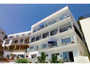 a large white building with balconies and tables at Hotel La Floridiana in Capri