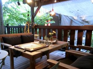 a wooden table and bench on a deck with a tent at Hakuba Kaze no Ko in Hakuba
