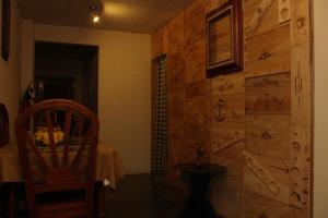 a room with a wooden wall with a chair and a table at Hostel Guayacan in Puerto Armuelles