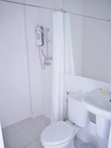 a white bathroom with a toilet and a sink at Kangsadan Resort in Loei