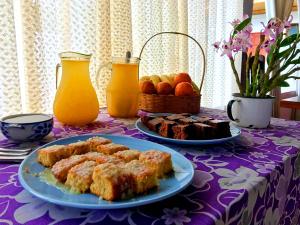a table with two plates of food and orange juice at Pousada Paraty in Paraty