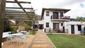 un patio con mesa y sillas frente a una casa en Casa Tzabar, en Villa de Leyva