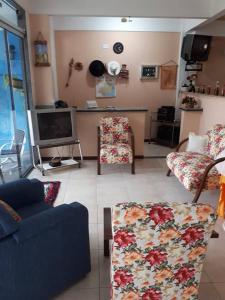 sala de estar con sofá y TV en Hospedagem Narcizo, en São Lourenço