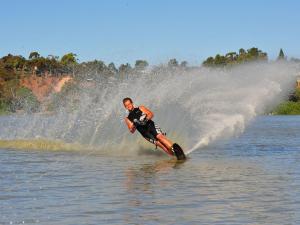 a man riding a water skis on top of a body of water at Riverbend Caravan Park Renmark in Renmark