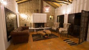 a living room with a couch and a stone wall at Casa Tzabar in Villa de Leyva