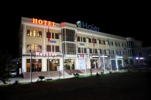 un edificio de hotel con un cartel de hotel por la noche en Hotel Naxshab, en Qarshi