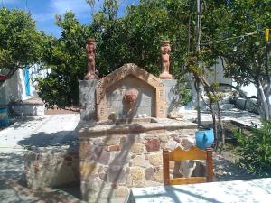 a stone fireplace with a chair in front of it at Dionysia Studios in Kefalos