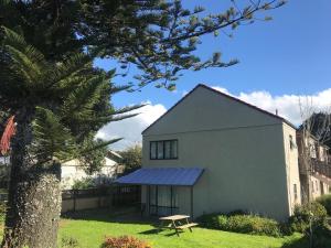 une maison blanche avec une table de pique-nique dans la cour dans l'établissement Royal Park Lodge, à Auckland