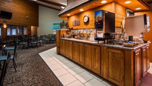 a restaurant with a bar with tables and chairs at Best Western Maritime Inn in Sturgeon Bay