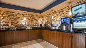 ein Fast-Food-Restaurant mit einer Bar mit einem TV in der Unterkunft Best Western Center Inn in Virginia Beach