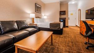 a hotel room with a couch and a bed at Best Western Thunder Bay Crossroads in Thunder Bay