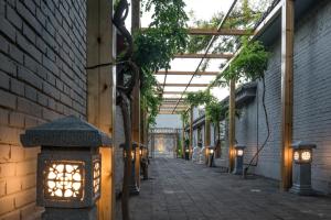 une passerelle avec des lumières sur le côté du bâtiment dans l'établissement Guipu Beihai Courtyard Hotel, à Pékin