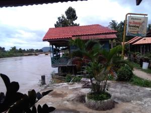 un bâtiment sur le bord d'une rivière dans l'établissement Tavendang Guesthouse, à Don Det