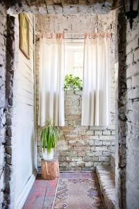 une fenêtre dans un mur de briques avec une plante en pot dans l'établissement Old Town cosy one bedroom apartments with fireplace, à Vilnius