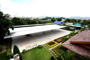 Cette chambre offre une vue sur un bâtiment blanc doté d'un jardin. dans l'établissement PN Gold Resort, à Bang Saen