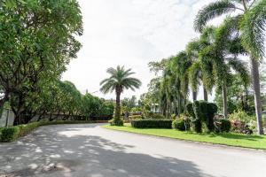 een straat met palmbomen aan de kant van een weg bij PN Gold Resort in Bangsaen