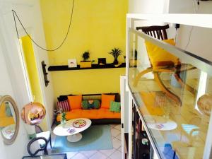 ナポリにあるIn Solitariaの黄色い部屋にリビングルーム(オレンジのソファ付)