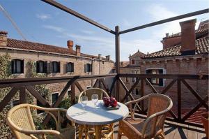 einen Tisch und Stühle auf dem Balkon eines Gebäudes in der Unterkunft Salmaso Apartments in Venedig